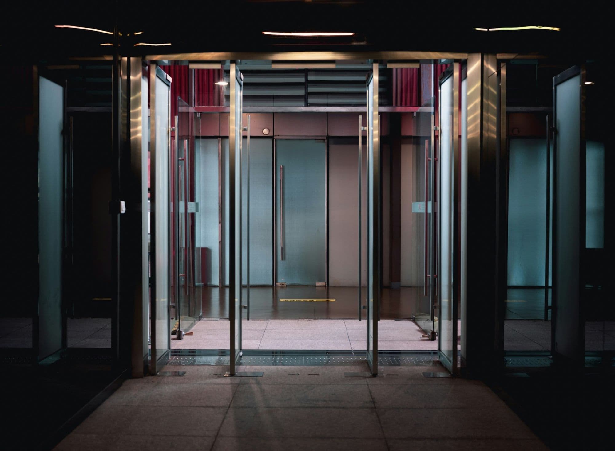 Glass sliding doors at a lit entrance at night